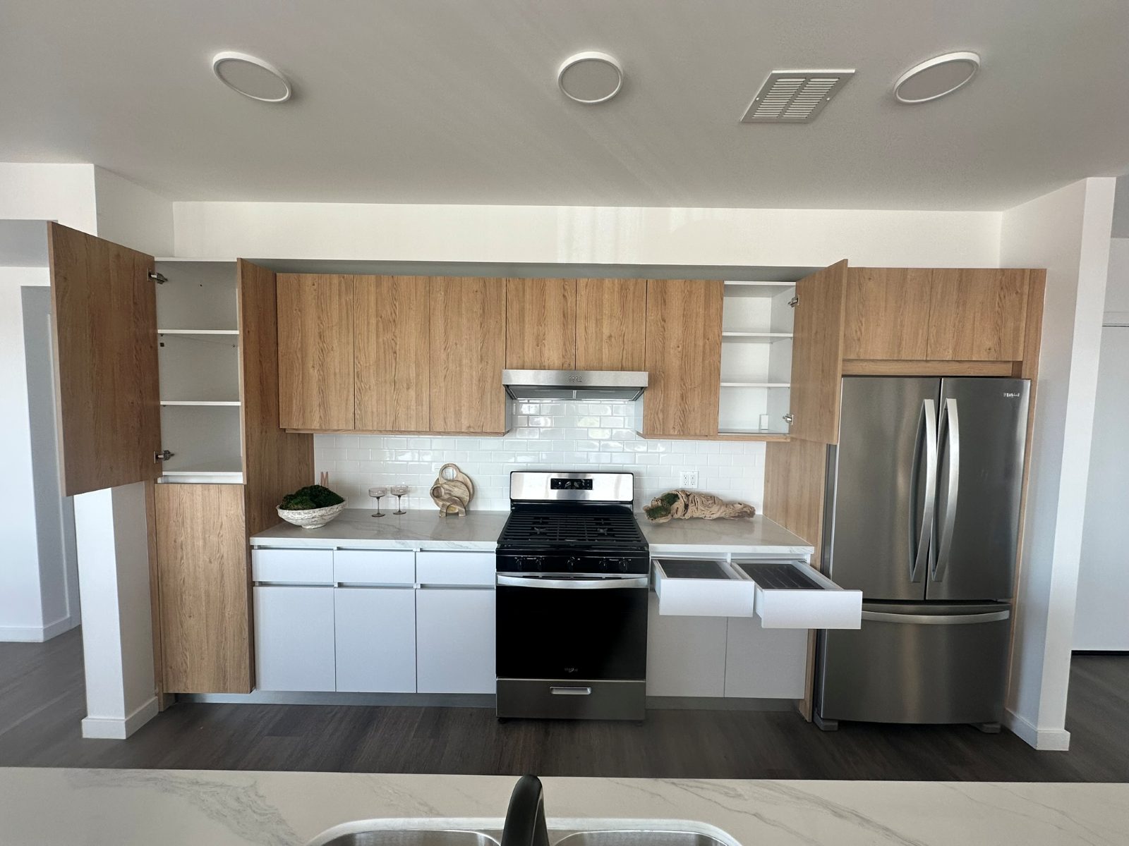 Kitchen after remodel with custom white oak cabinets and stone counters in Costa Mesa